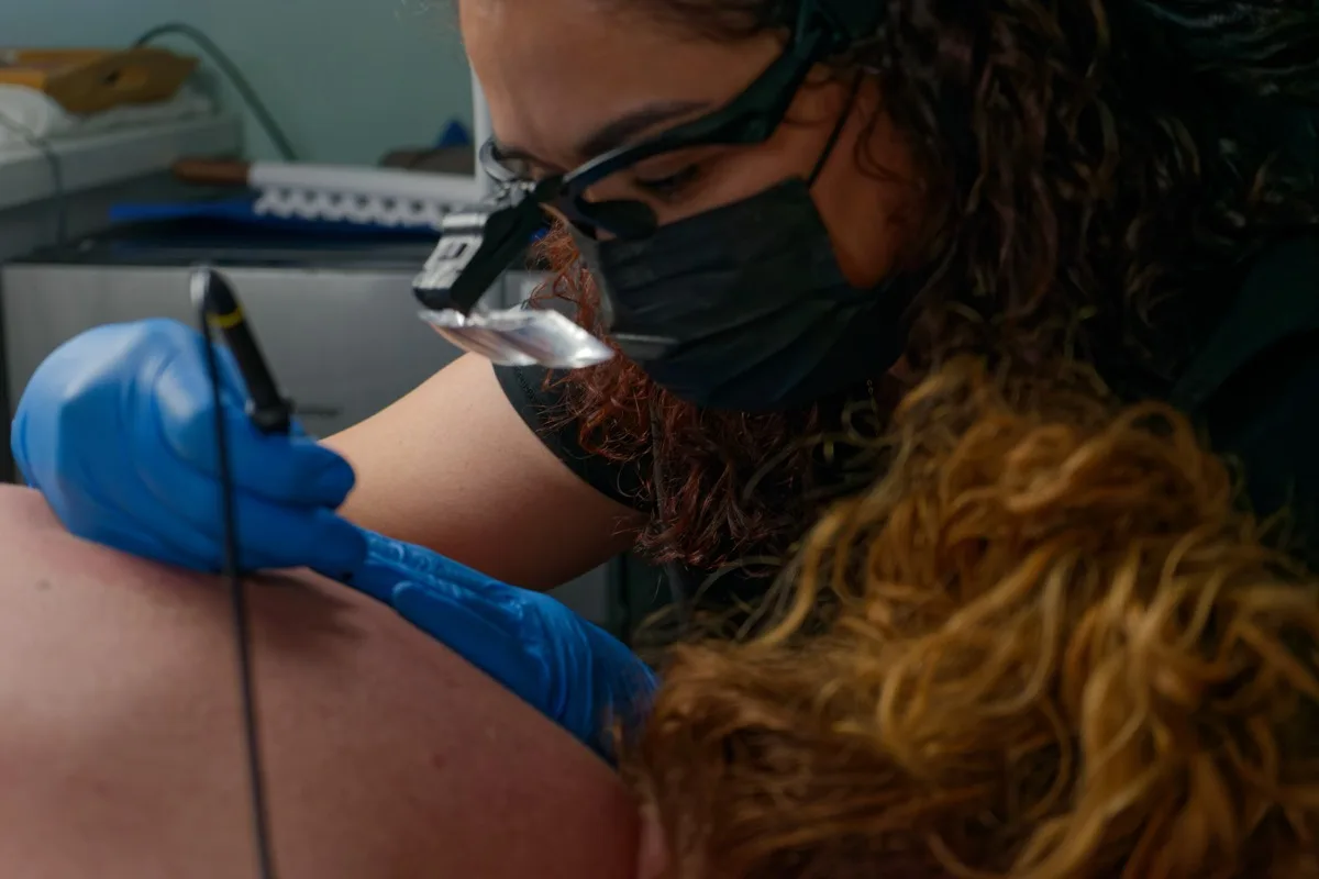 Aiyani performing Skin Sheek treatment on a client's back at Central Coast Red Coral Spa